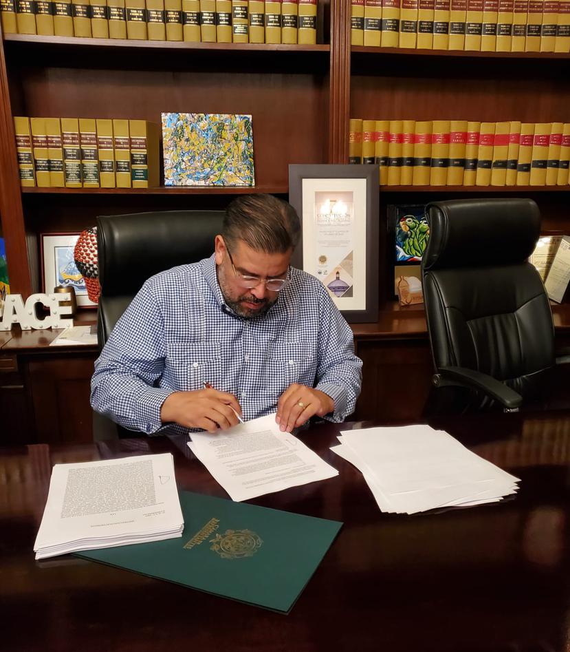 Momento en que el presidente de la Cámara, Rafael "Tatito" Hernández, firma el informe de conferencia del Proyecto de la Cámara 1367 que modifica el impuesto a las foráneas.
