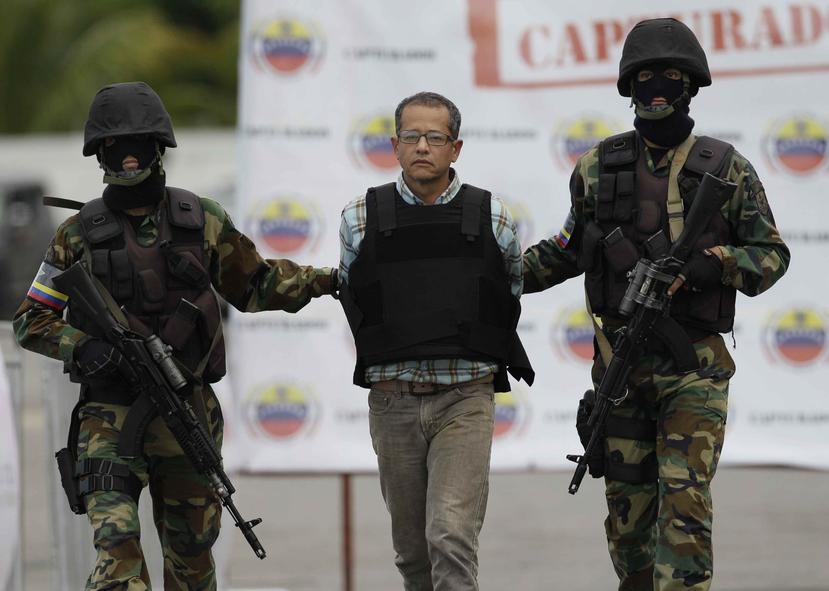 El colombiano Jorge Milton Cifuentes Villa es escoltado por agentes poco antes de ser deportado. (AP)