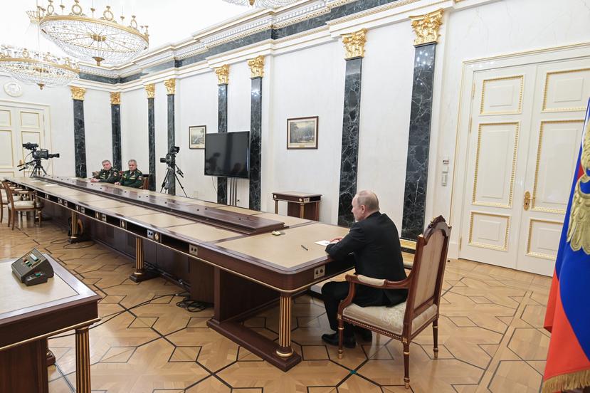 Far away, Vladimir Putin (right) talks with his Defense Minister Sergey Shoigu (second from left) and the Chief of the General Staff of the Russian Armed Forces and First Deputy Defense Minister Valery Gerasimov.