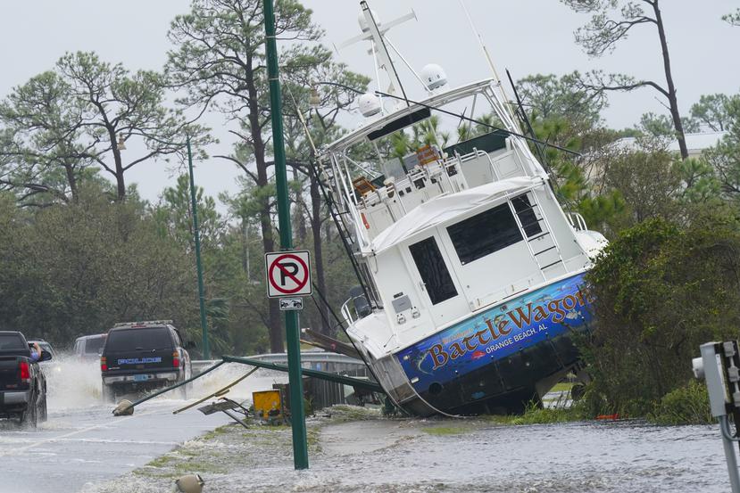 Los vientos y la marejada ciclónica del huracán Sally depositaron un bote en la orilla de una carretera en Orange Beach, Alabama.