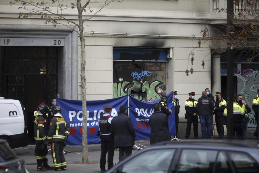Policías y bomberos trabajan en la escena de un incendio en un edificio ocupado por intrusos, en Barcelona, el 30 de noviembre de 2021. (Kike Rincón/Europa Press vía AP)