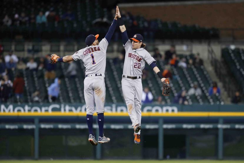 Carlos Correa (1) y Josh Reddick (22)  celebran la victoria de los Astros ante Detroit. (AP)