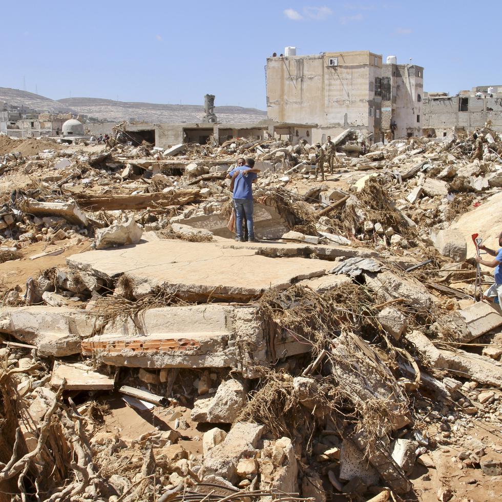 Varias personas buscan sobrevivientes entre la devastación causada por las inundaciones en Derna, Libia.