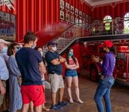 Melina Aguilar Colón, fundadora de Isla Caribe, explica a un grupo de turistas la importancia histórica del Parque de Bombas.