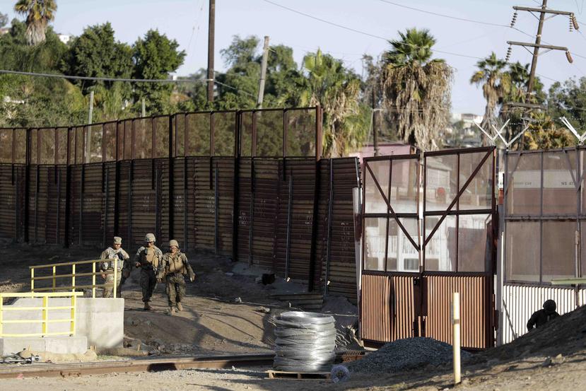 Infantes de marina patrullan una valla fronteriza que separa a Tijuana, México, en el fondo, y San Diego, cerca del cruce fronterizo de San Ysidro, en California. (AP)