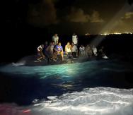 En esta foto, suministrada por la Real Fuerza de Defensa de Bahamas, se ve a sobrevivientes sobre un bote volcado mientras aguardan a ser rescatados cerca de Nueva Providencia, Bahamas.
