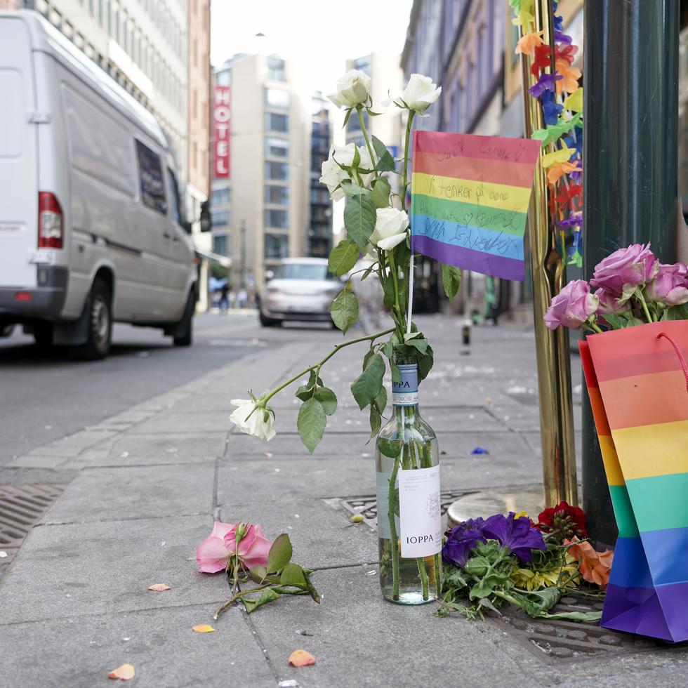 Flores acompañadas por los colores del orgullo LGBTQ+ yacen en el sitio donde un hombre armado se puso a disparar, el sábado 25 de junio de 2022, en el centro de Oslo.