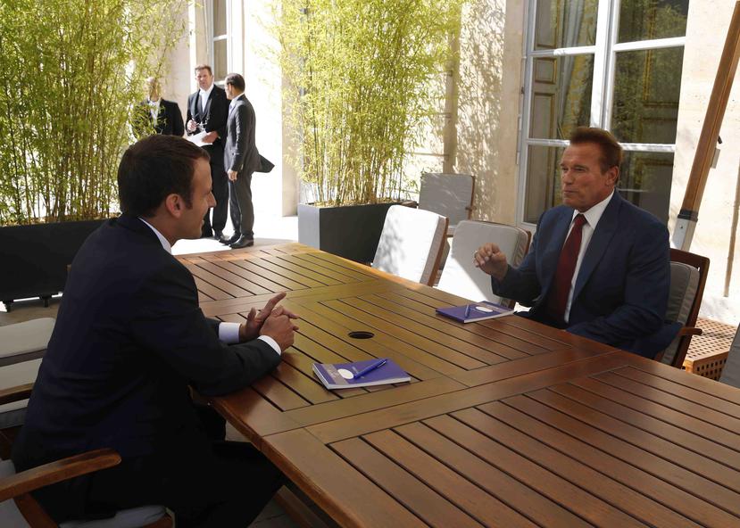 Arnold Schwarzenegger conversa con el presidente francés Emmanuel Macron. (AP)