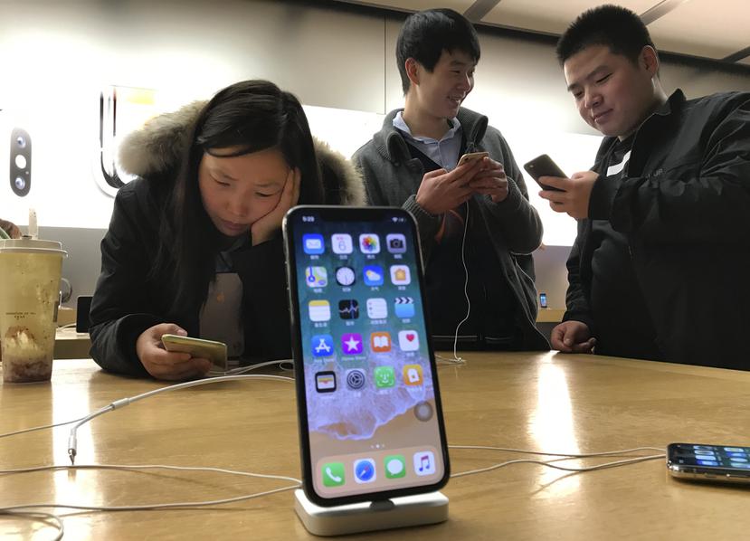 Clientes mirando celulares en una tienda en Pekín, China.