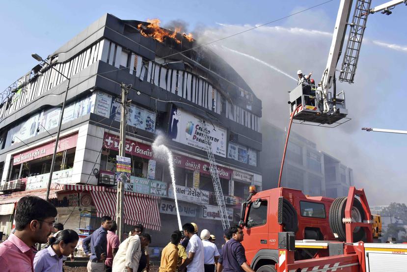 Los bomberos combaten las llamas en un edificio en Surat, en el estado de Gujarat, India, el viernes 24 de mayo de 2019. (AP / Sarju Parekh)