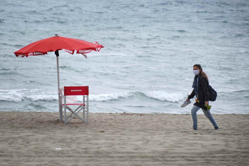 Una mujer camina por una de las playas en Italia que continúa por la fase 2 de reapertura. (AP)