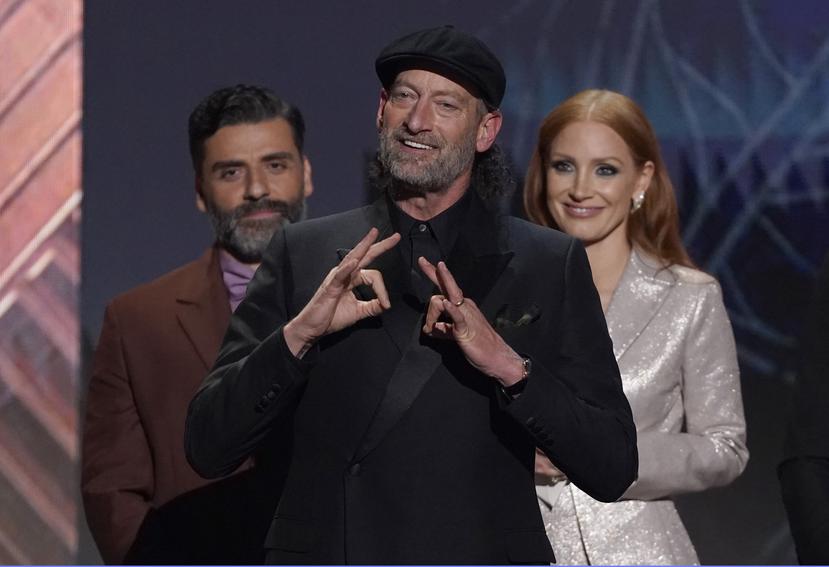 Troy Kotsur recibe el Premio SAG al mejor actor de reparto, por "CODA", el domingo 27 de febrero de 2022 en el Barker Hangar en Santa Mónica, California. Atrás, Oscar Isaac, a la izquierda, y Jessica Chastain.