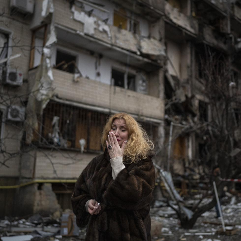 Natali Sevriukova, abrumada por la emoción, en el exterior de su destrozado edificio de apartamentos tras un ataque con proyectiles en Kiev, Ucrania, el 25 de febrero de 2022.