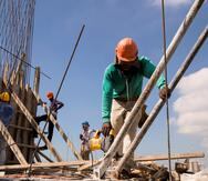 Obreros trabajan en la construcción de una edificación que se levantan en el Distrito Nacional, en Santo Domingo (República Dominicana), en una fotografía de archivo. EFE/ Orlando Barría
