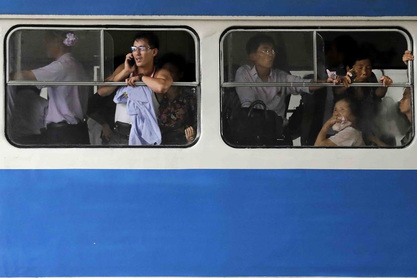 Un coreano conversa por teléfono mientras se encuentra en un transporte público. (AP)