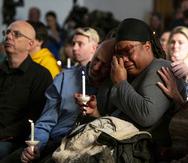 Tyrice Kelley, center right, a performer at Club Q, is comforted during a service held at All Souls Unitarian Church following an overnight fatal shooting at the gay nightclub, in Colorado Springs, Colo., on Sunday, Nov. 20, 2022. (Parker Seibold/The Gazette via AP)