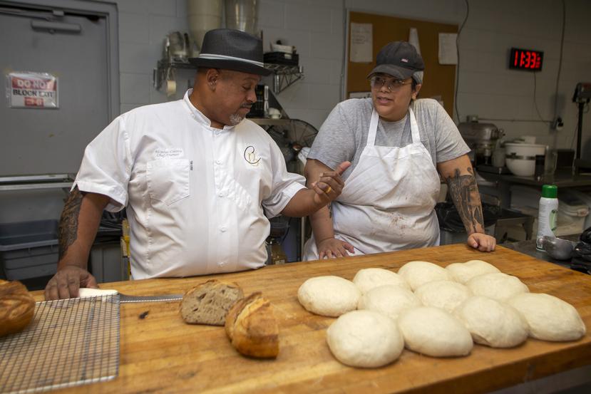 Castro conversa con una empleada mientras preparan la masa del pan.