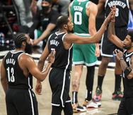 De izquierda a derecha, James Harden, Kevin Durant y Kyrie Irving, de los Nets de Brooklyn, festejan durante el primer partido de una serie de playoffs el 22 de mayo de 2021. El proyecto de juntar a los tres grandes anotadores nunca cuajó, y el equipo no estuvo ni siquiera cerca de ser contendor al título de la NBA.