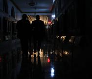 Invitados al mensaje del gobernador en el Capitolio pasan por un pasillo a oscuras.