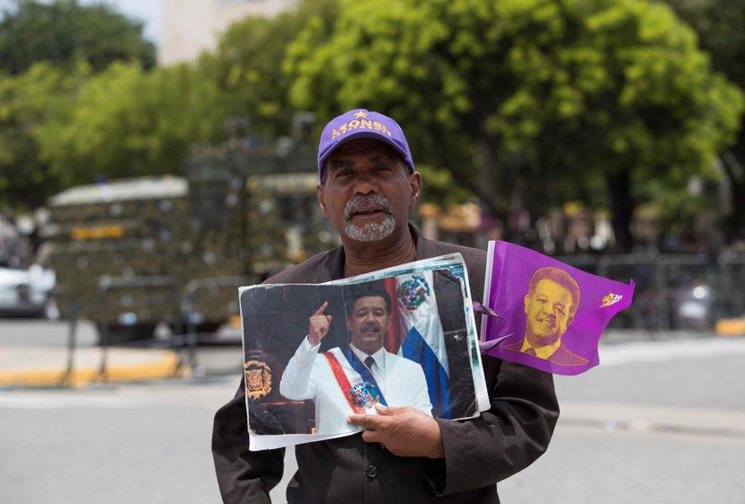 Un seguidor del expresidente dominicano Leonel Fernández muestra imágenes del exmandatario, durante una manifestación en Santo Domingo. (EFE)