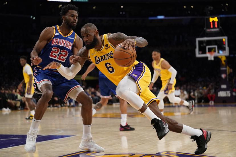 LeBron James, de los Lakers, maneja el balón contra Andrew Wiggins (22), de los Warriors.