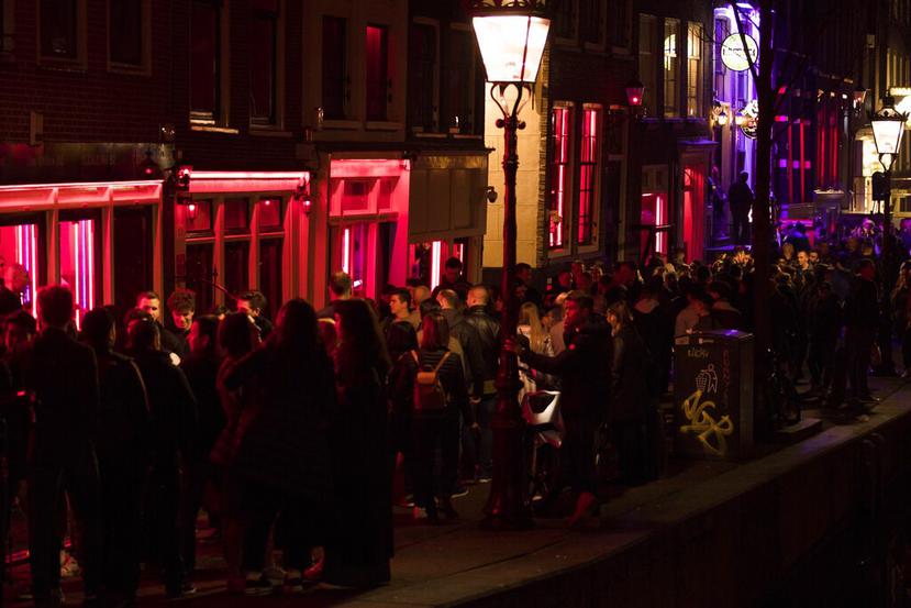 Multitudes de turistas agolpados frente a las vitrinas con trabajadoras sexuales en la zona roja de Amsterdam. (AP / Peter Dejong)