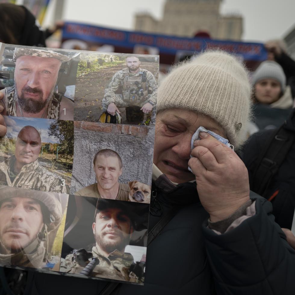 La madre ucraniana Valentina Diachuk, de 59 años, sostiene una foto de su hijo desaparecido Mykola Diachuk y sus compañeros de armas durante una manifestación en el centro de Kyiv, Ucrania.