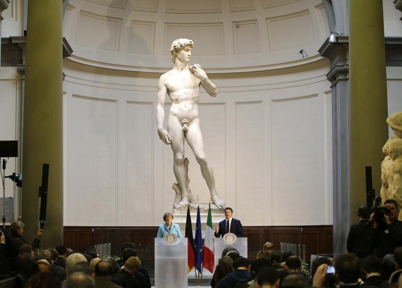 En una foto de archivo, se puede observar la enorme estatua y joya del Renacimiento, el "David" de Miguel Ángel, en exhibición permanente en el museo Galleria dell'Accademia, en Florencia, Italia. Abajo, a aparecen la canciller alemana Angela Merkel, izquierda, y el primer ministro italiano Matteo Renzi, en una conferencia de prensa el 23 de enero de 2015.
