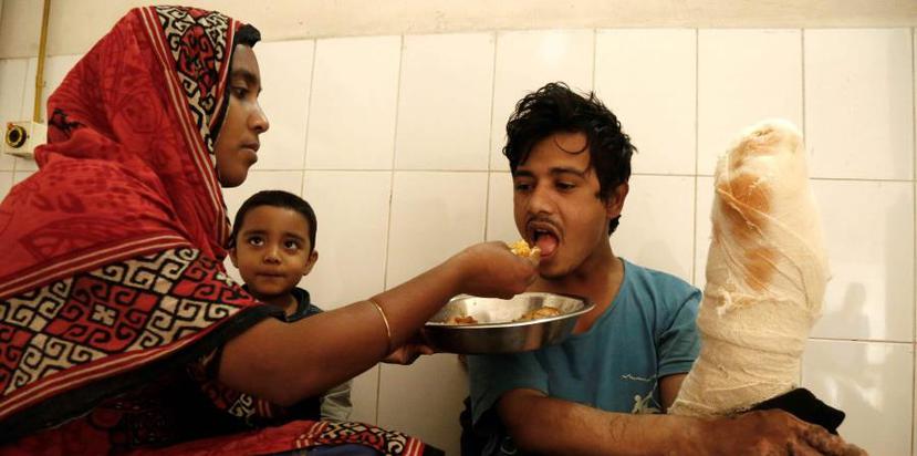 Abul Bajandar, conocido como 'hombre árbol', recibe comida de manos de su esposa, Halima Akter en una habitación de la unidad de quemados del hospital, en Daca, Bangladesh. (EFE / Abir Abdullah)