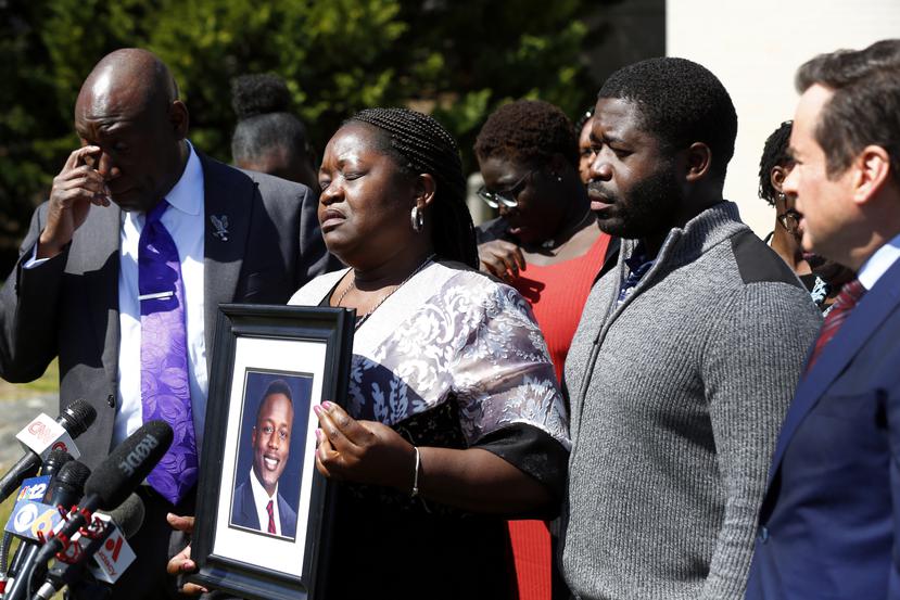 Caroline Ouko, madre de Irvo Otieno, muestra un retrato de su hijo acompañada del abogado Ben Crump, a la izquierda, su hijo mayor, Leon Ochieng, y el abogado Mark Krudys.