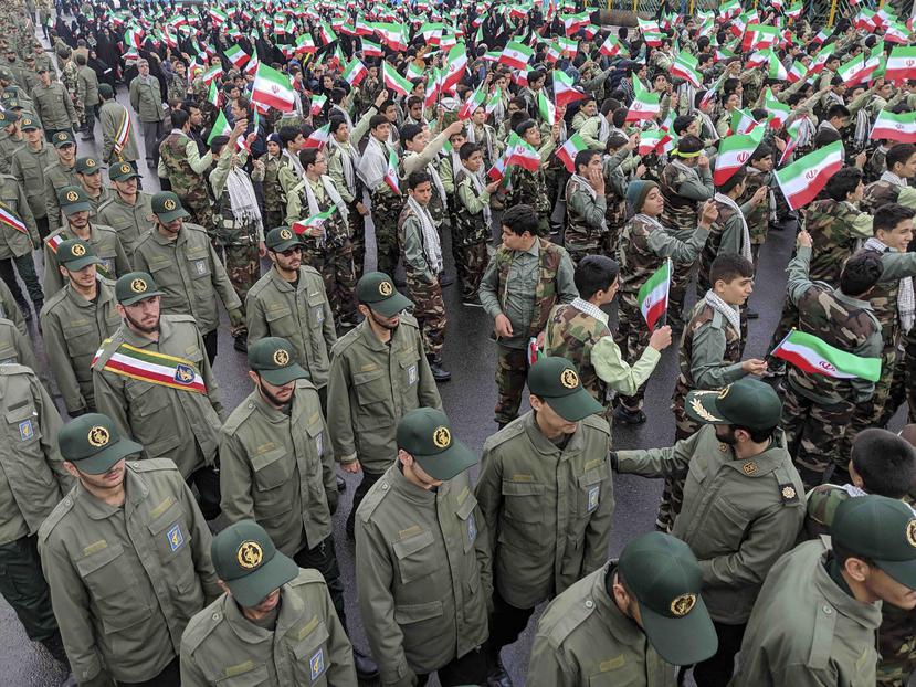 Un grupo de personas ondean banderas de Irán mientras miembros de la Guardia Revolucionaria llegan a Azadi, la Plaza de la Libertad, durante un acto para celebrar el 40mo aniversario de la Revolución Islámica, en Teherán, Irán (AP /Vahid Salemi)