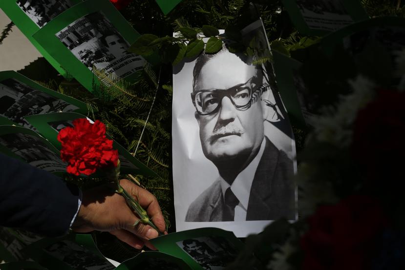 Santiago de Chile - Un hombre deja una flor sobre la imagen del presidente chileno Salvador Allende, este viernes en Santiago.