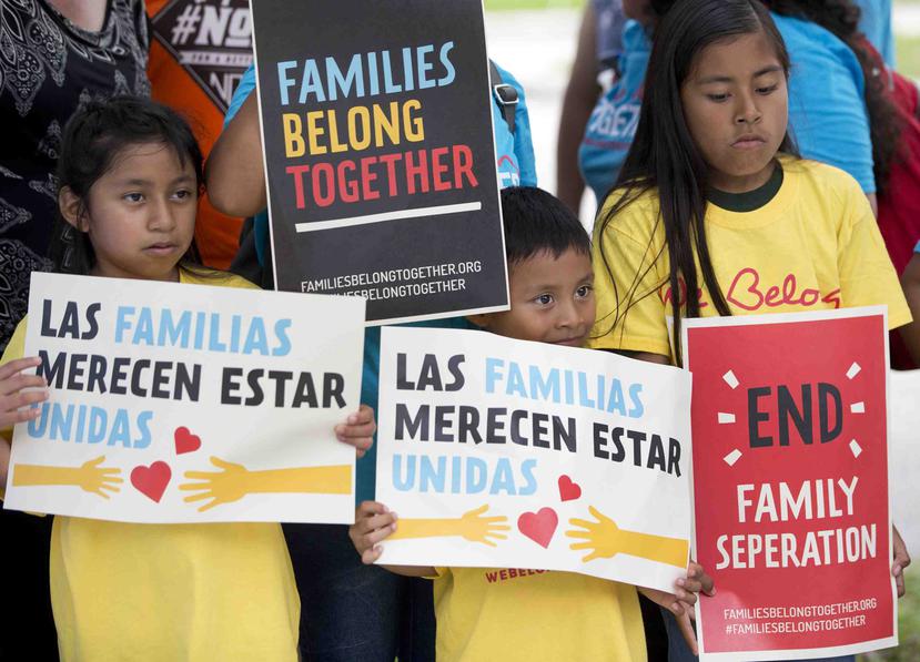 Niños sostienen carteles durante una manifestación frente de la oficina del Servicio de Control de Inmigración y Aduanas en Miramar, Florida. (AP)