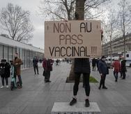 Una persona sostiene un cartel con el mensaje "¡No al pase de vacunas!", en una protesta contra el pase de vacunas contra el COVID-19 en Francia.