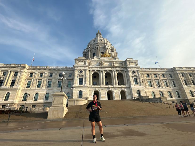 Pamela Mercado Michelli, corredora del PUR 10K, frente al edificio de la legislatura de Minnesota.