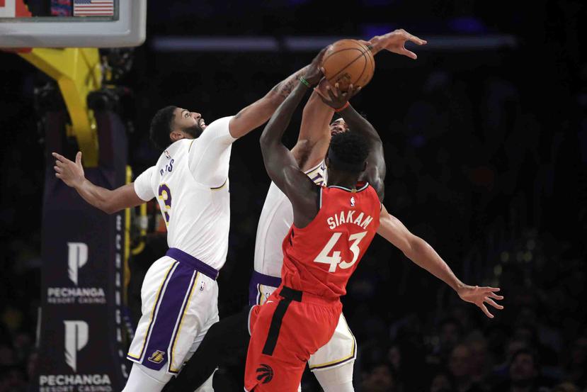 El jugador de los Lakers de Los Ángeles Anthony Davis, a la izquierda, bloquea un lanzamiento del jugador de los Raptors de Toronto Pascal Siakam (43) durante la primera mitad del juego. (AP)