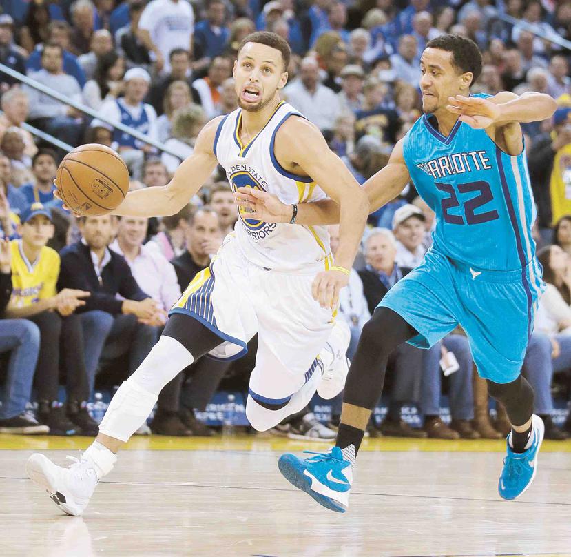 Las estrellas de la NBA, Stephen Curry, de los Golden State Warriors, y de los Charlotte Hornets, Brian Roberts, durante una jugada en la pasada temporada de la NBA.