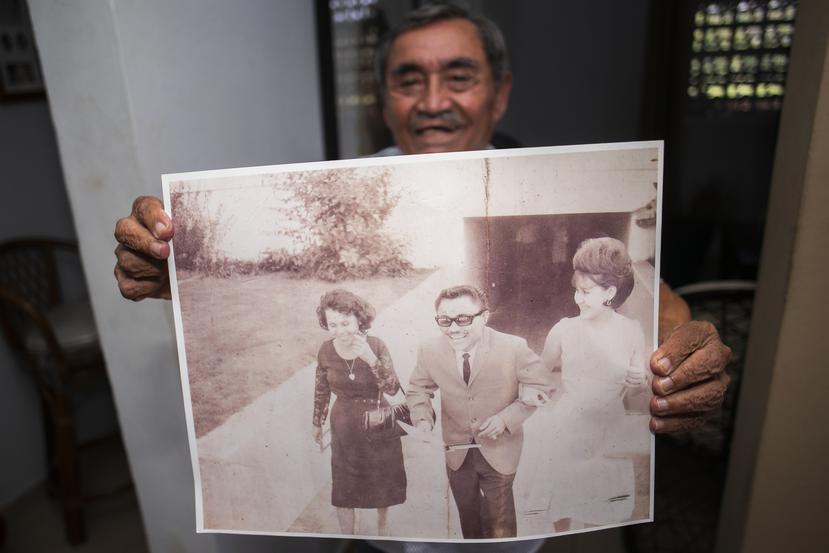 Odilio muestra una foto del día de su boda. A la izquierda se encuentra su madre y a la derecha su esposa Silvia.