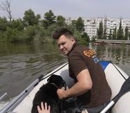 Un equipo de rescate animal se desplaza el jueves 8 de junio de 2023 en una embarcación con un perro al que han salvado en una zona inundada tras la ruptura de una represa en Jersón, Ucrania.