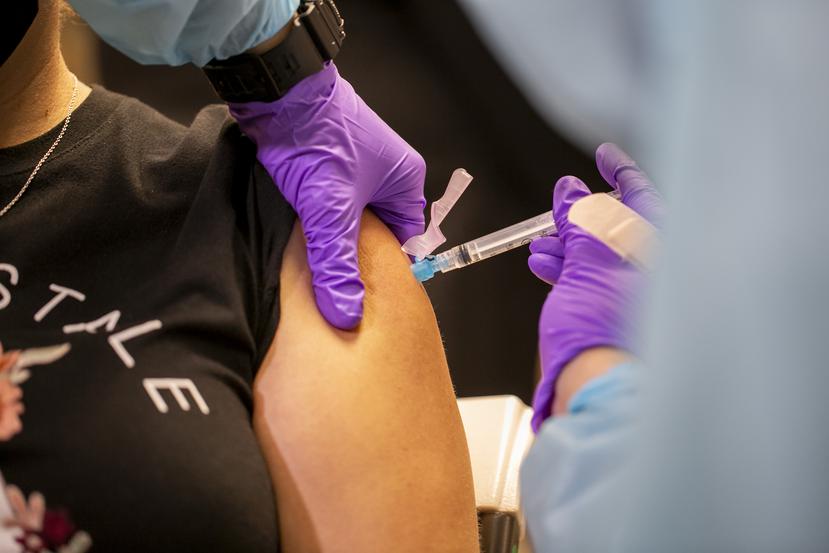 Personal de Salud administra una vacuna contra el COVID-19 en el aeropuerto Luis Muñoz Marín.