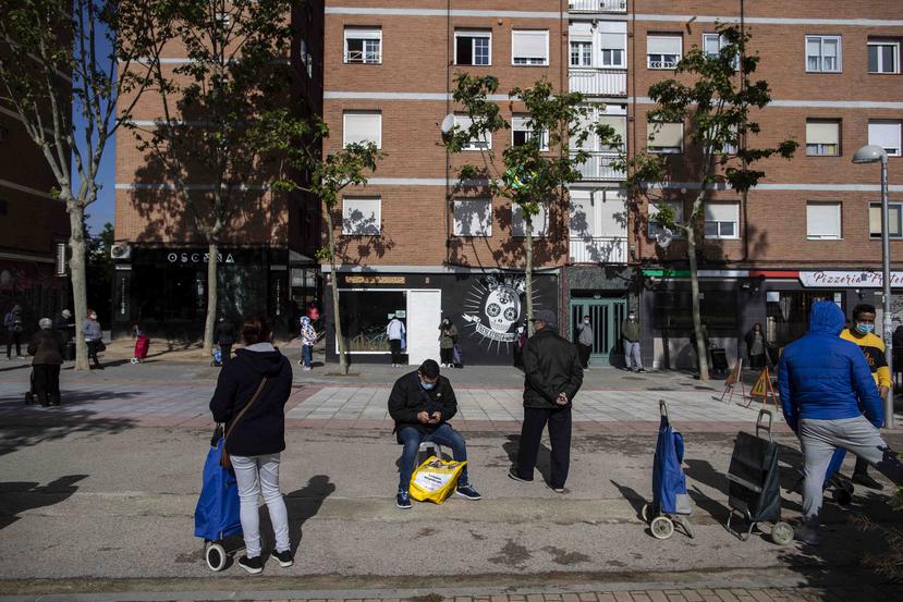 Personas esperan por recibir una donación de comida en Madrid, España. (AP)