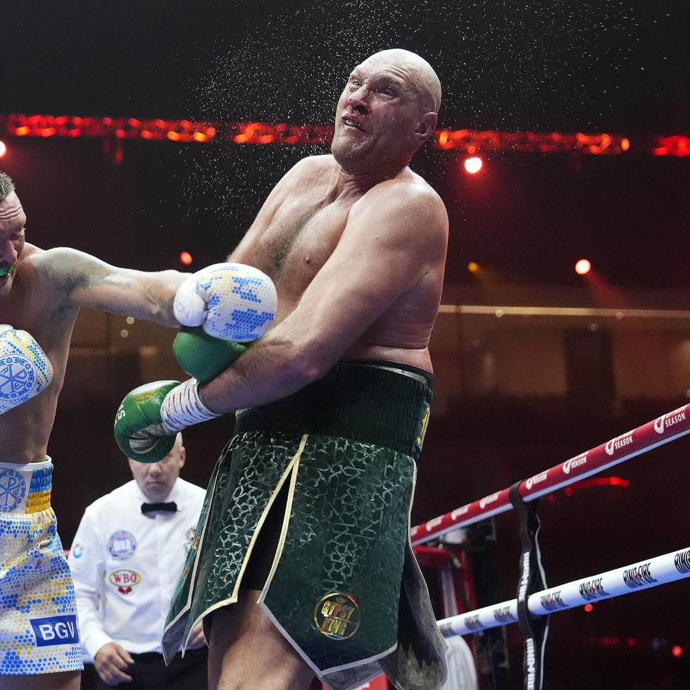 El británico Tyson Fury (derecha) recibe un golpe del ucraniano Oleksandr Usyk durante su pelea por el campeonato mundial indiscutible del peso pesado.
