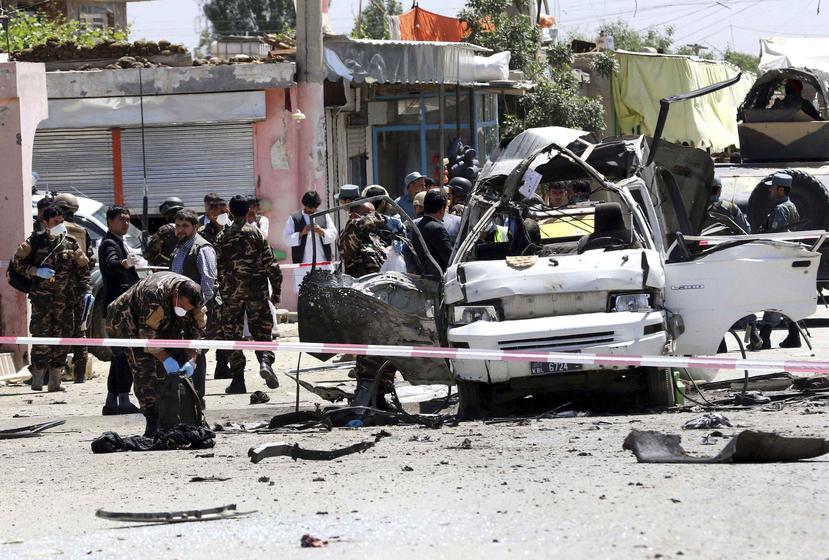 Agentes afganos inspeccionan el lugar donde se ha producido un ataque suicida con bomba contra un autorbús que transportaba personal del Departamento de Justicia en Kabul. (EFE)