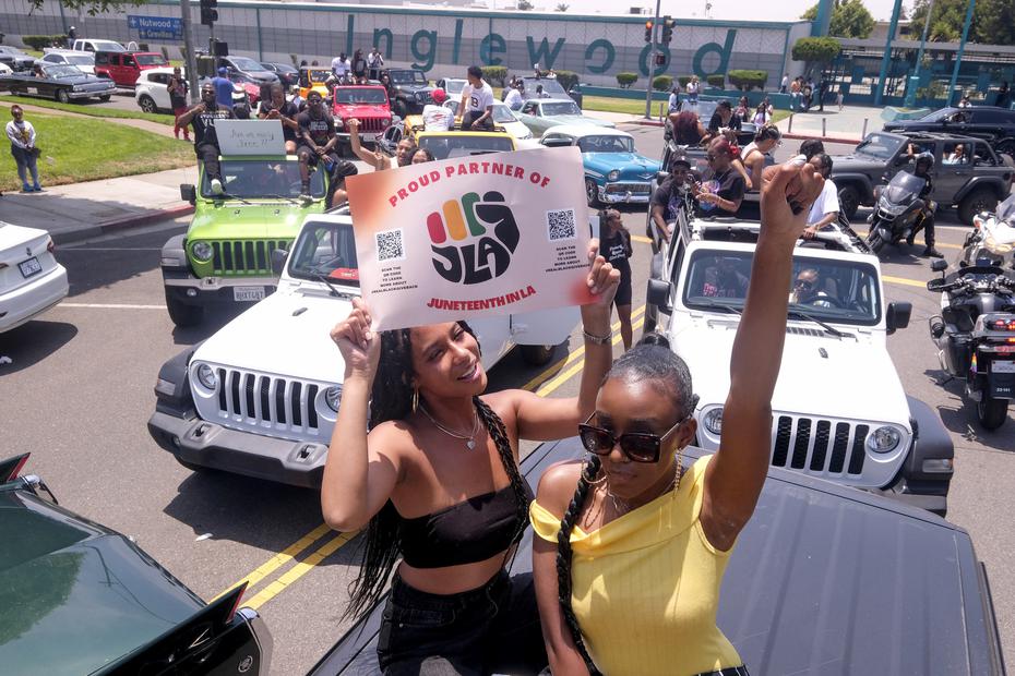 Jasmine Kingi, a la izquierda, de 26 años, y Robin Renee Green, de 26 años, ambas de Los Ángeles, celebran mientras participan en un desfile de coches para conmemorar el Juneteenth, el sábado 19 de junio de 2021, en Inglewood, California.