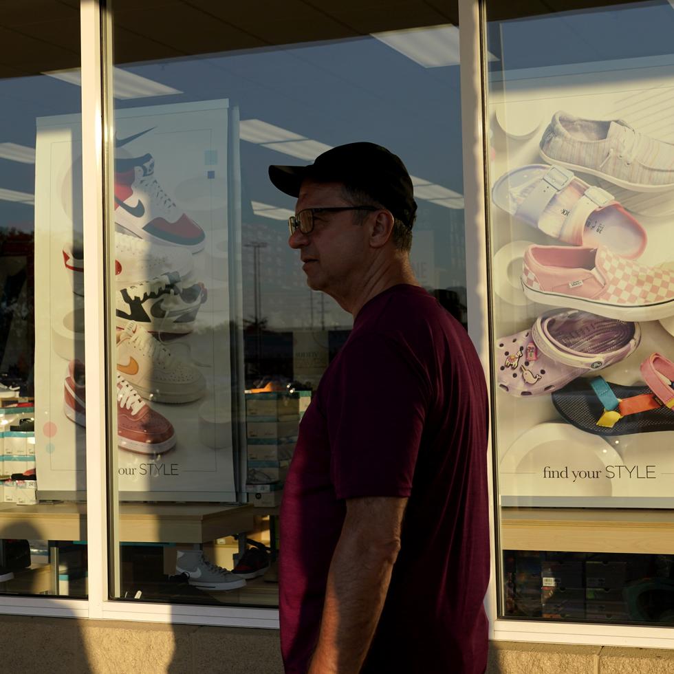 Un consumidor pasa por al frente de una tienda de zapatos.