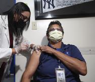 La epidemióloga Myriam Cotto vacuna a Anette Santiago, empleada del San Jorge Children Hospital en San Juan.