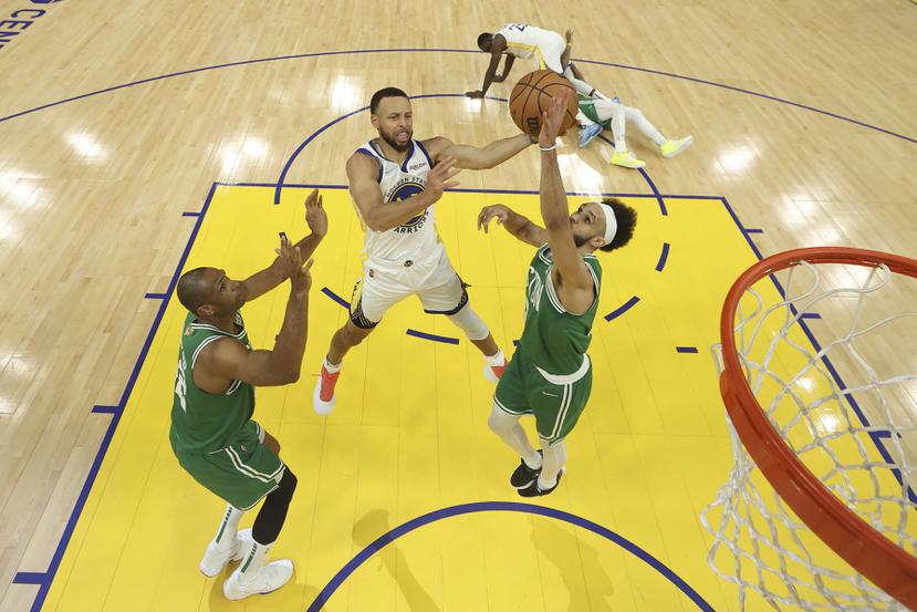 El escolta de los Warriors, Stephen Curry (en el medio), dispara contra el centro de los Celtics, Al Horford (izquierda) y el escolta Derrick White durante la primera mitad del segundo juego de las Finales de la NBA en San Francisco.