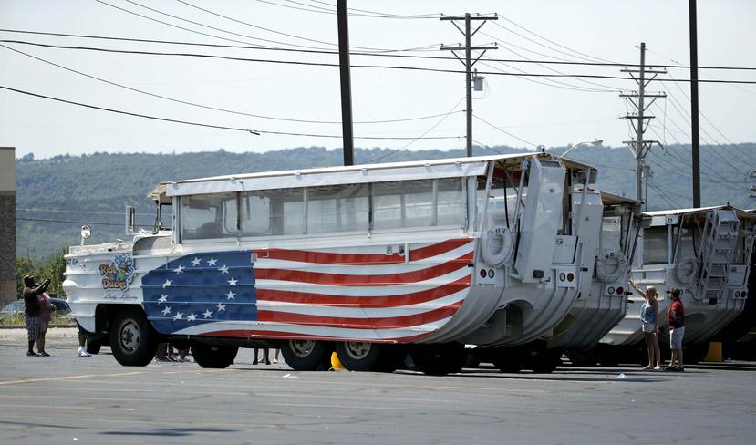 Personas observan embarcaciones anfibias turísticas n una terminal de estos vehículos en Branson, Missouri. (AP)