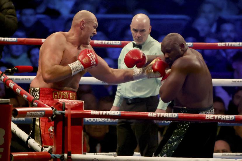 Tyson Fury conecta al rostro de Derek Chisora durante la pelea de título mundial en Londres.