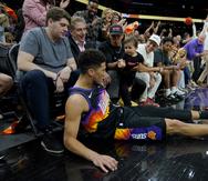 Devin Booker cae fuera de las líneas en un momento de la primera mitad del partido entre los Suns de Phoenix y los Pelicans de Nueva Orleans.